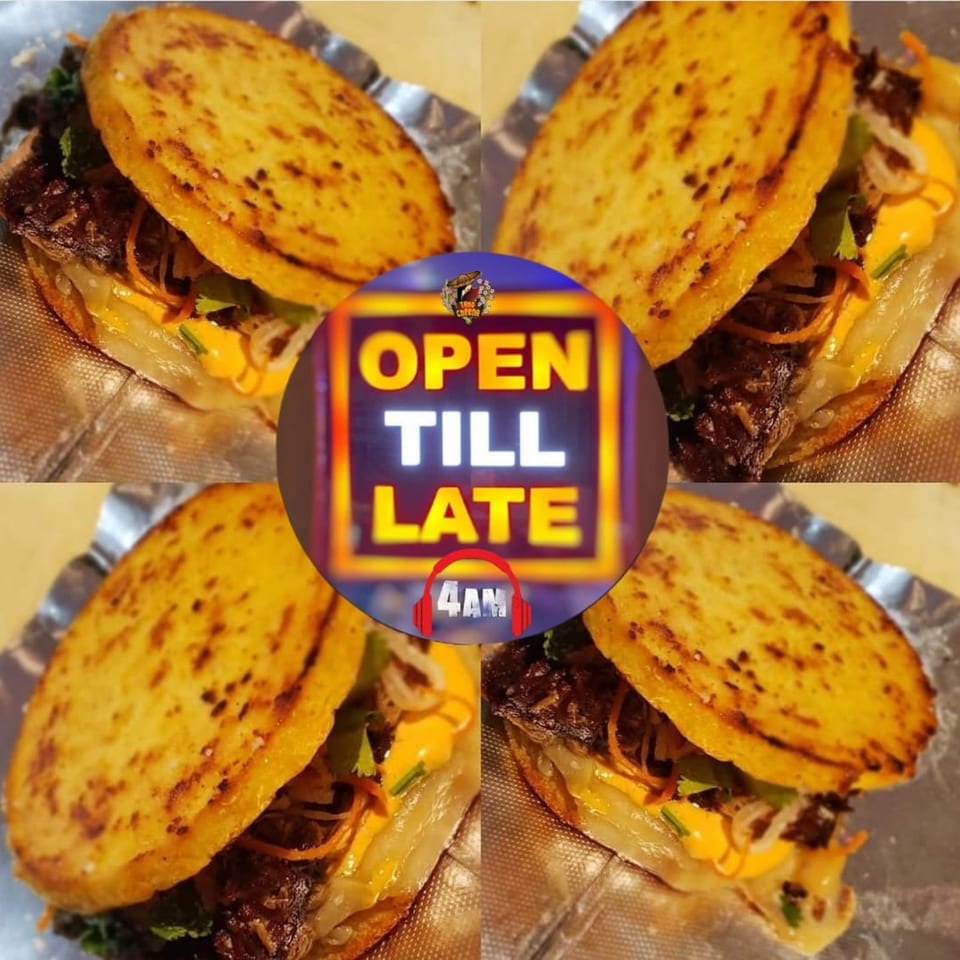 Four Asian-fusion tacos with crispy shells, meat, cheese, and vegetables, with an "Open Till Late 4AM" sign.